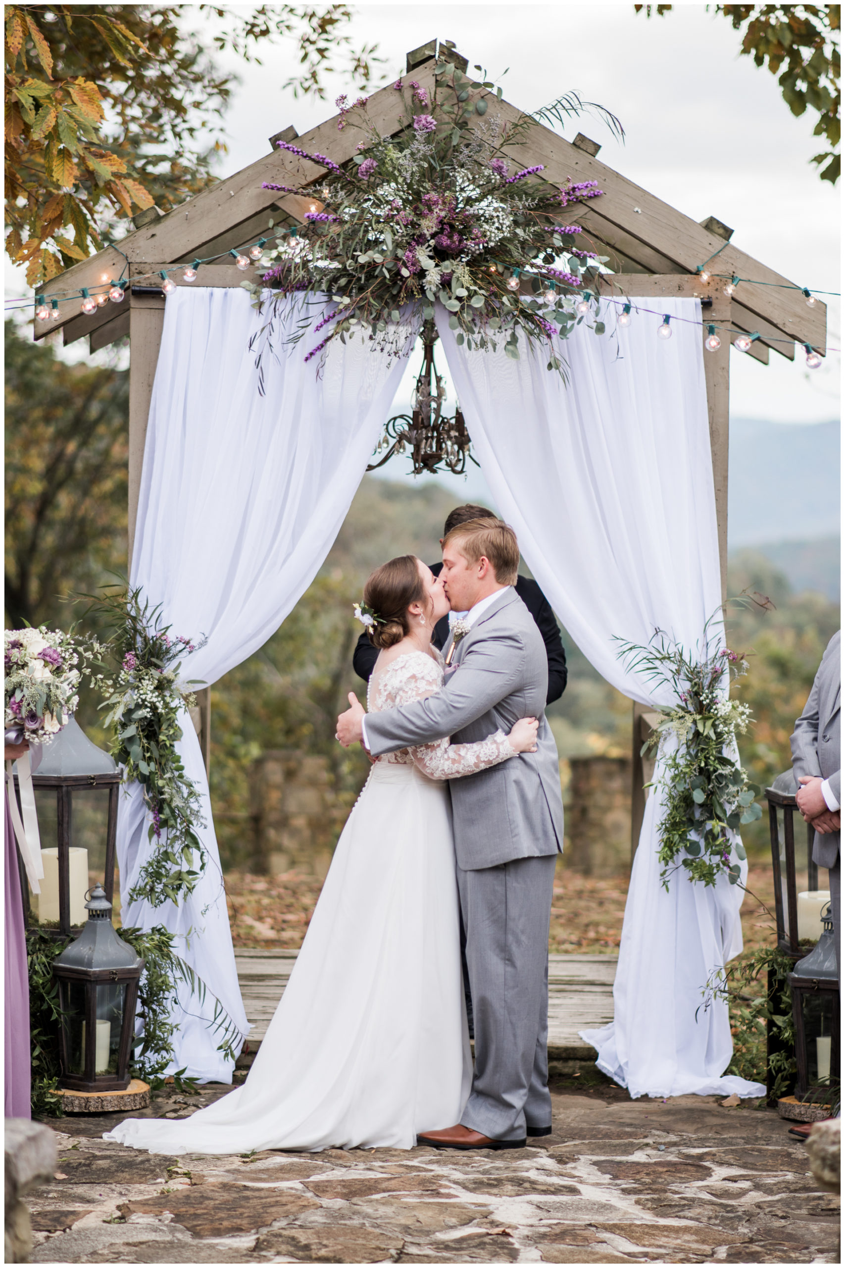 First Kiss under Outdoor Arbor with Chandelier and white draping Monte Sano Lodge Fall Wedding