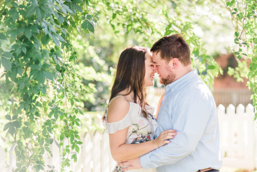 Romantic engagement photo with a man and woman leaning in for a kiss